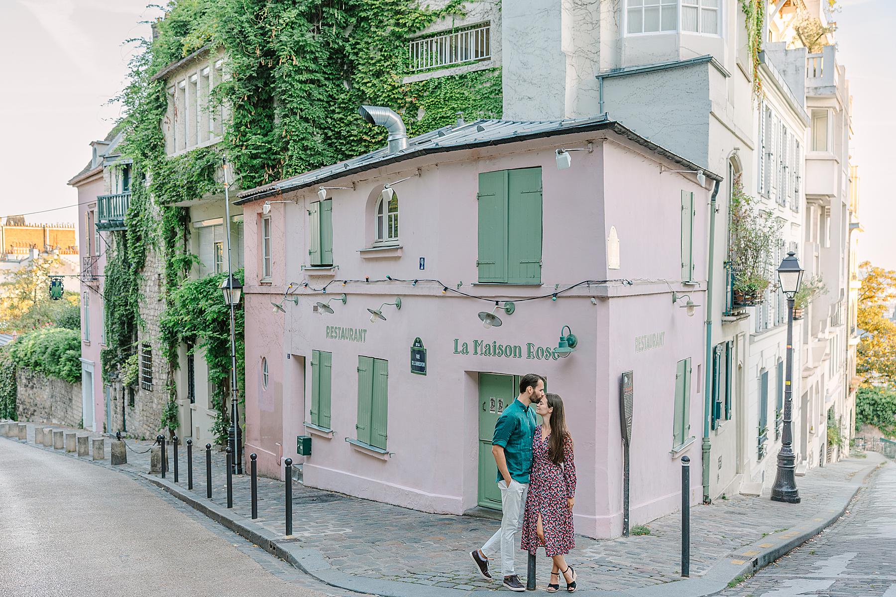 Couple sharing a quiet moment in front of La Maison Rose during their Montmartre couple photoshoot in Paris