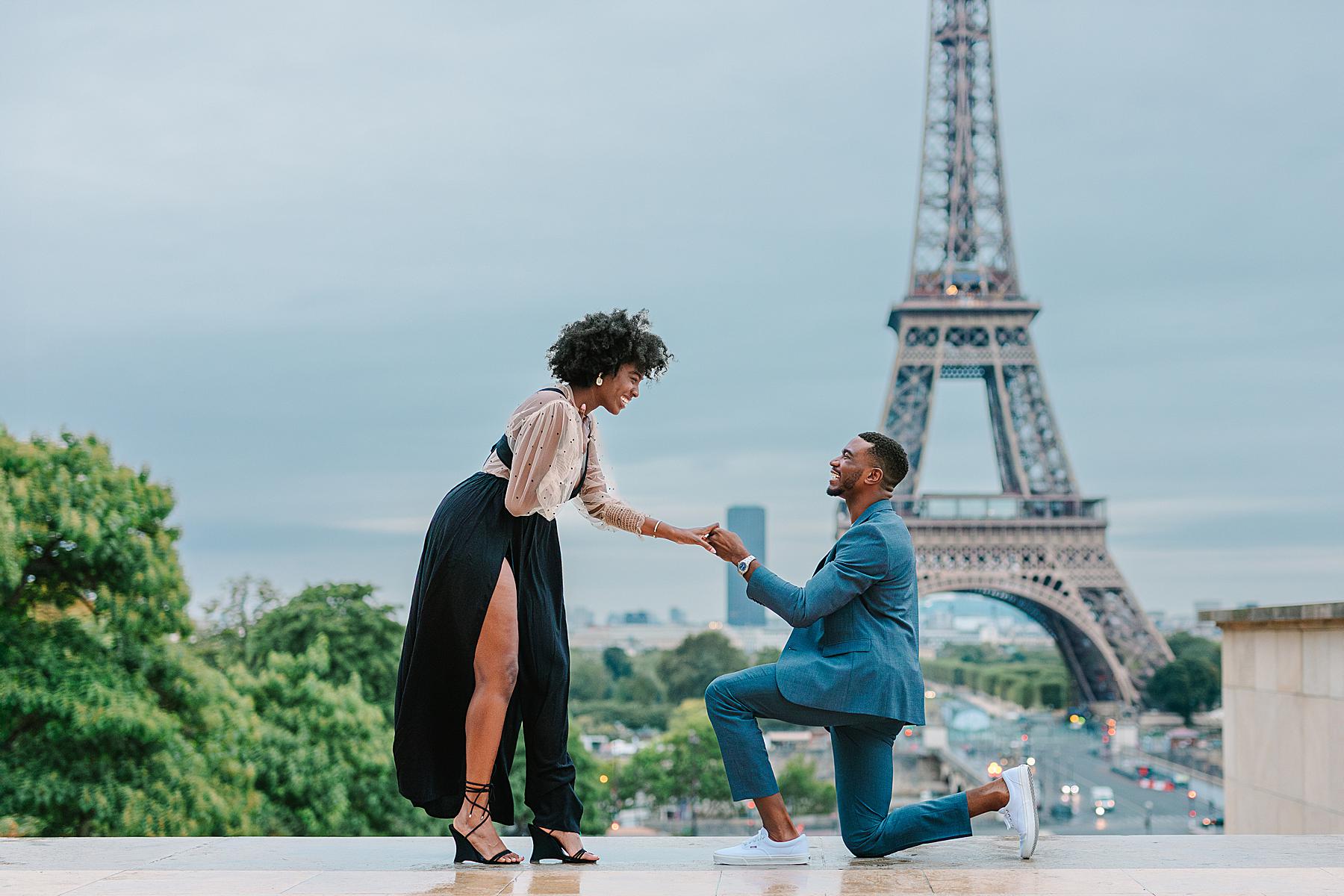 Man proposing to his partner in front of the Eiffel Tower at sunrise during a surprise proposal at Trocadéro, captured during a Paris proposal photoshoot